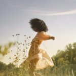 امرأة أنيقة تتجول في حديقة خضراء، تمثل الاستمتاع بالروتين اليومي وتحويل الحياة العادية إلى لحظات شاعرية.